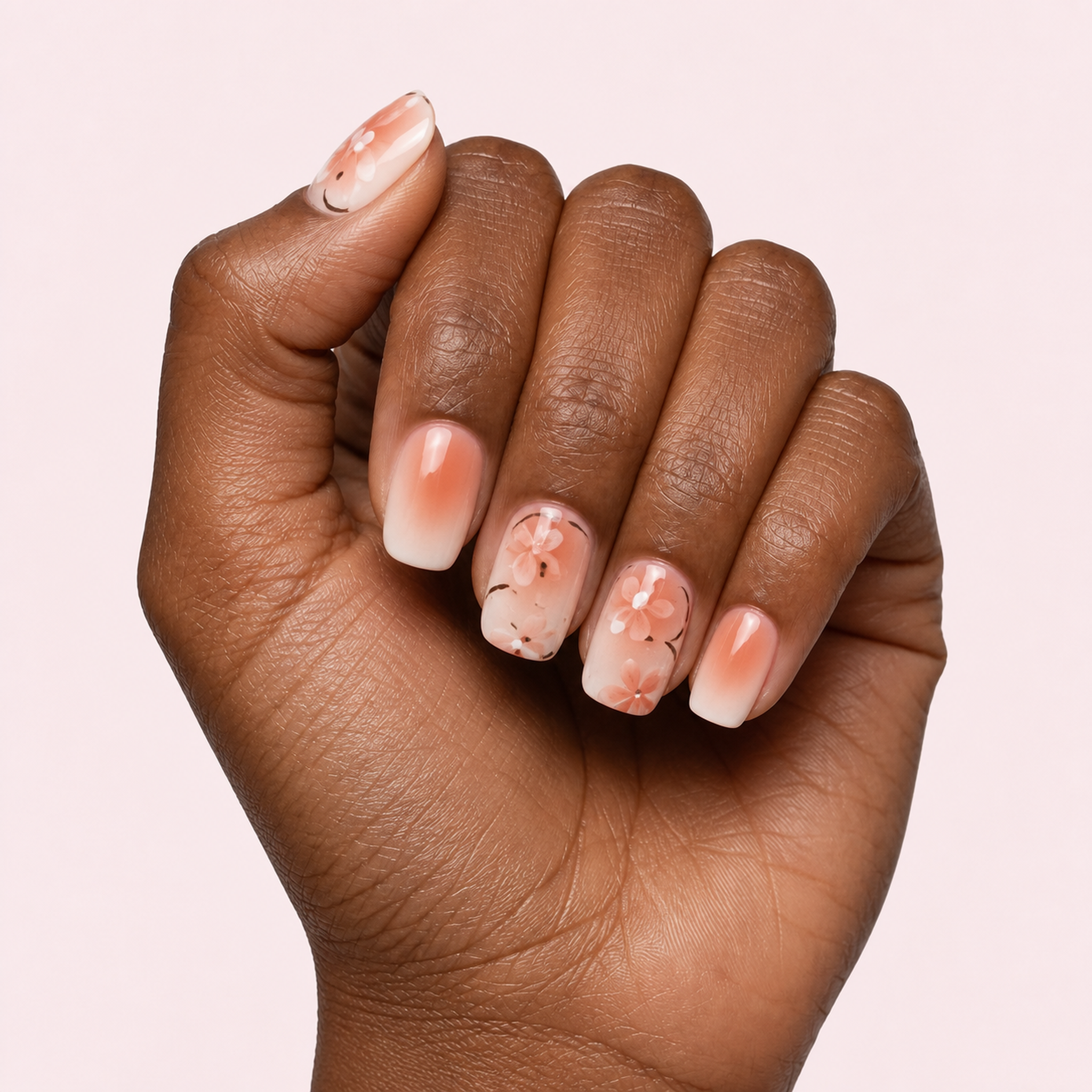 Peach and gold marble gel nail strips worn on a deep skin tone hand