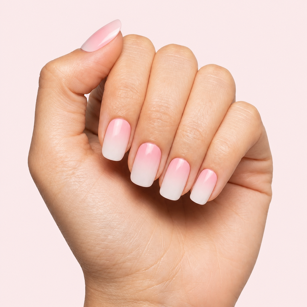 Pink and white ombre baby boomer gel nail strips worn on a light skin tone hand