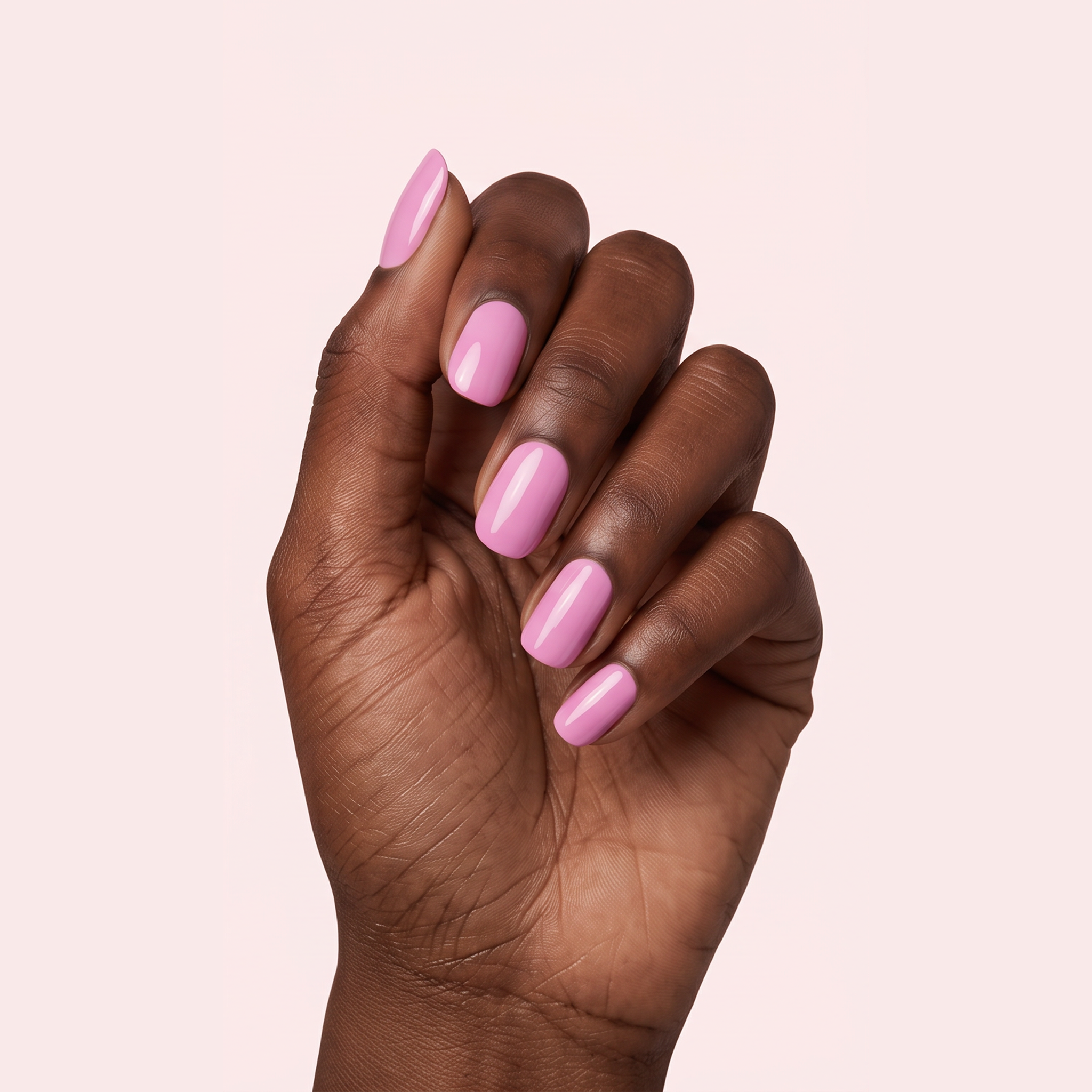 Orchid pink gel nail strips worn on a deep skin tone hand