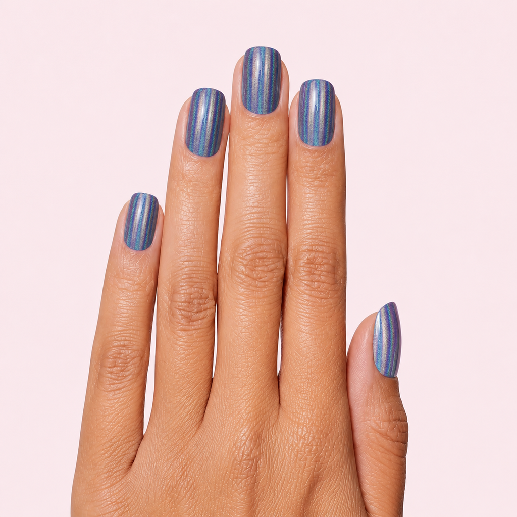 Blue grey gel nail strips with gold vertical stripes worn on a tan olive skin tone hand
