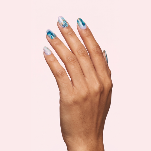 Blue and white marble swirl gel nail strips worn on a tan olive skin tone hand