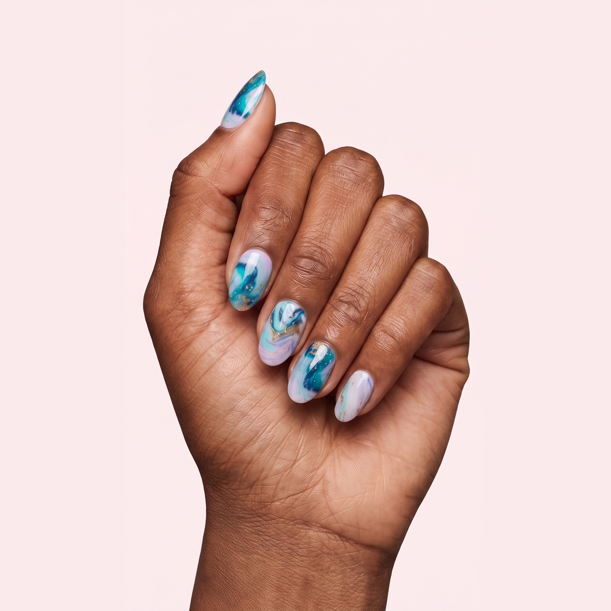 Blue and white marble swirl gel nail strips worn on a deep skin tone hand