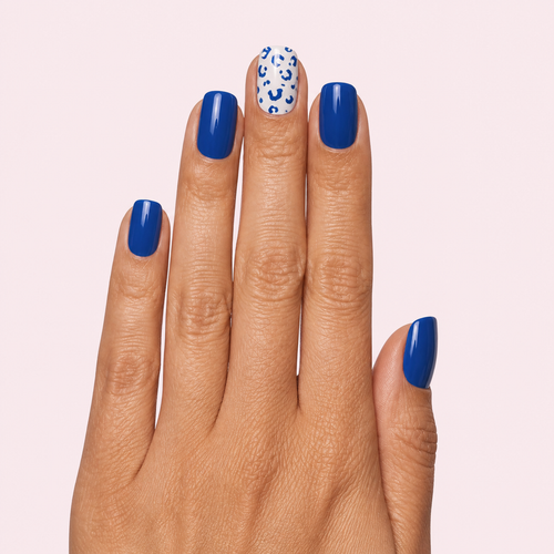 Navy blue and white leopard print gel nail strips worn on a tan olive skin tone hand